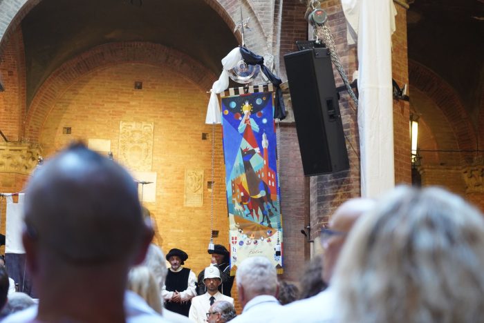 Palio di Siena 16 agosto, barberi in corsa tra terreno e celeste nel drappellone di Guasco