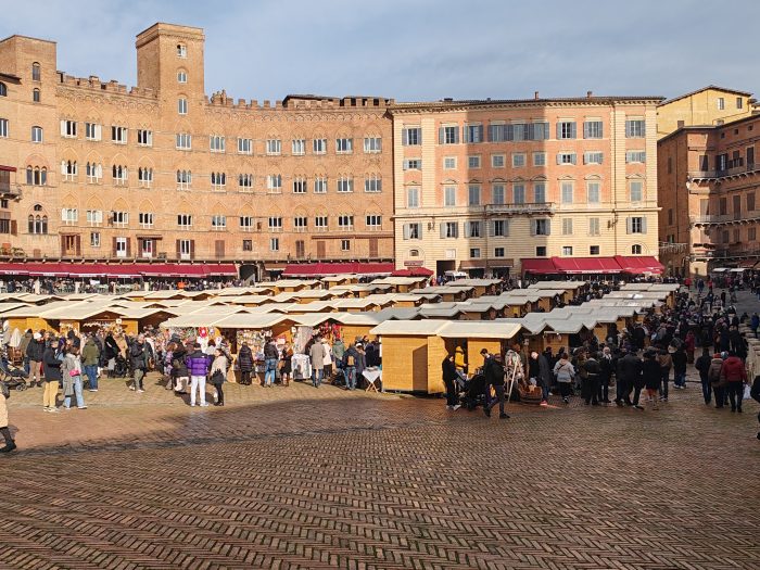 Mercato nel Campo, l'aria frizzante e il sole colorano la piazza insieme a tanti senesi e turisti